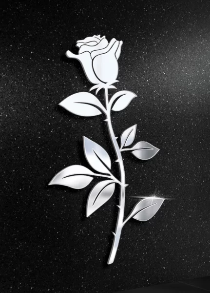 Stalowa figura róży z liśćmi na tle nagrobka