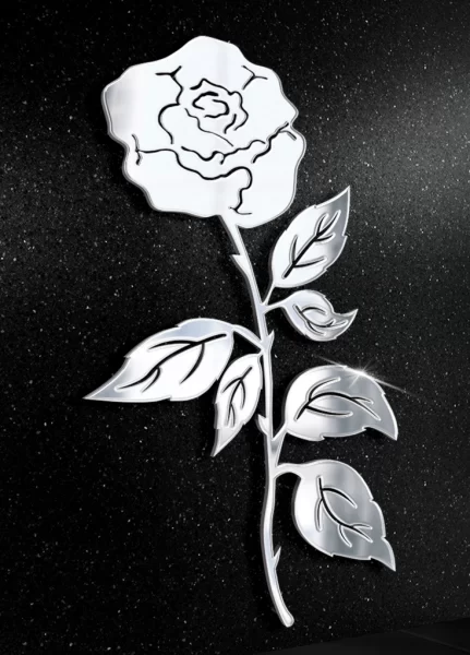 Stalowa figura róży na tle nagrobka, symbol piękna i pamięci